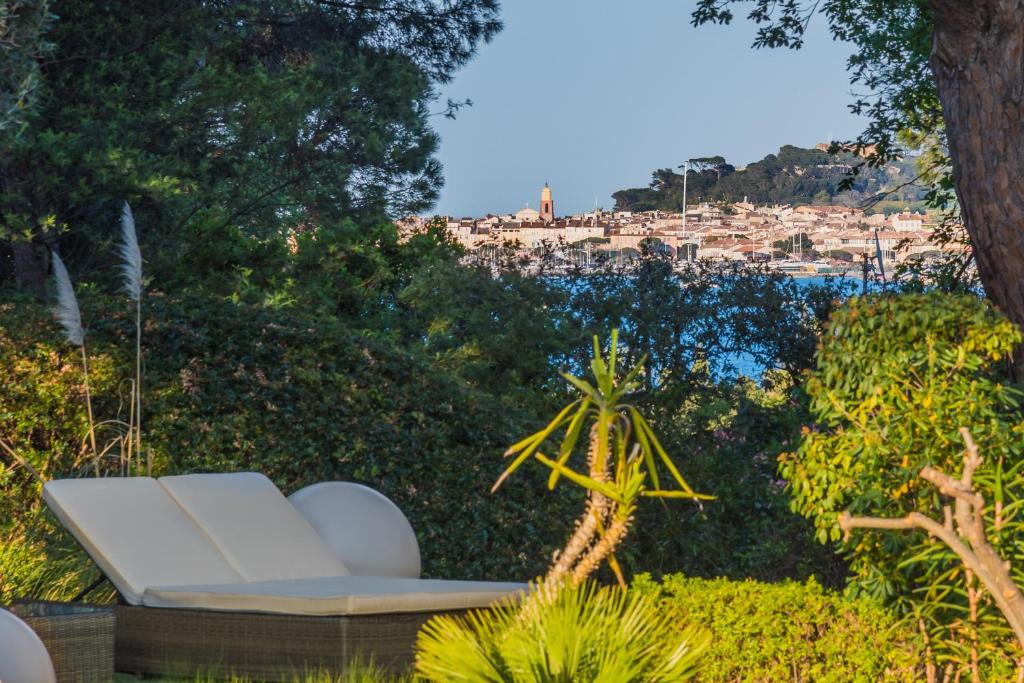 圣特罗佩Les Capucines Saint Tropez的花园内的白色沙发,享有城市美景