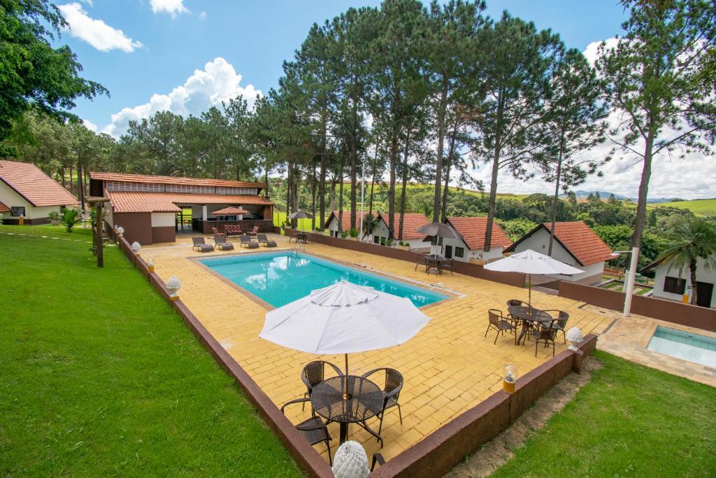 索科罗Hotel Dona Paschoalina的一张带桌子和遮阳伞的游泳池的图片