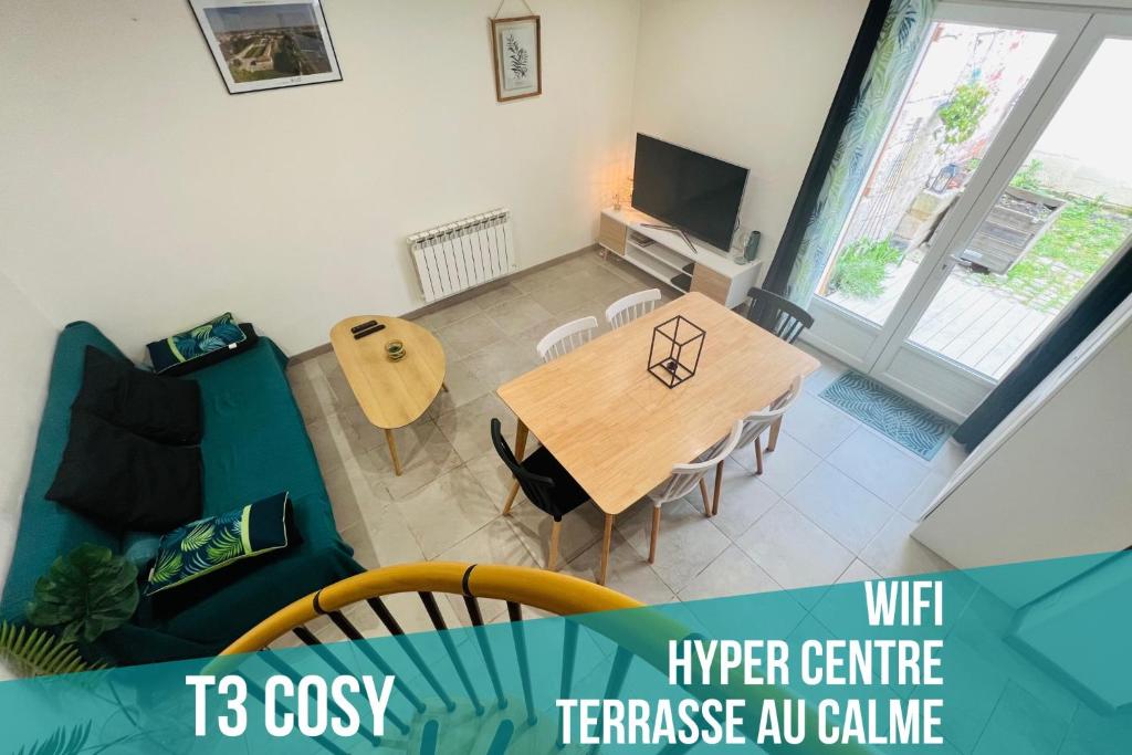 罗什福尔T3 COSY MAISON DE VILLE TERRASSE AU CALME的客厅配有桌子和蓝色沙发