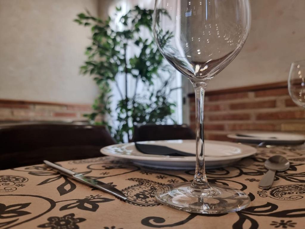 La PueblanuevaHostal Restaurante CASA FRAN的一张桌子,上面放有酒杯和盘子