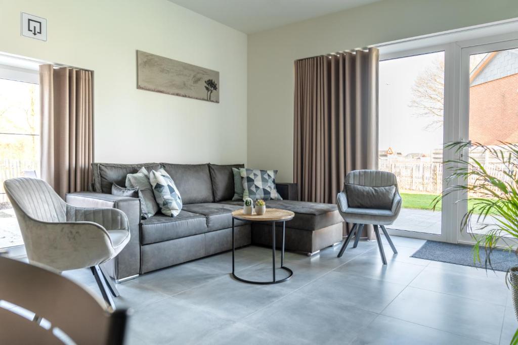 NeerpeltDe Hoog Velden 12的客厅配有灰色的沙发和椅子