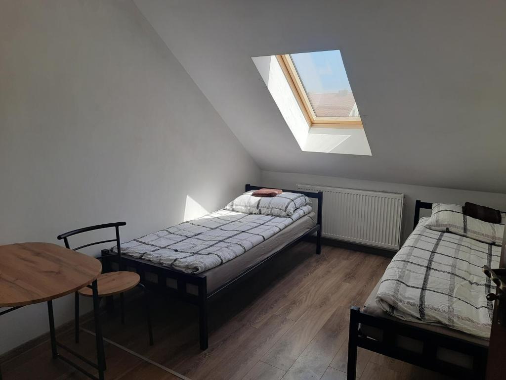 特切夫Pokoje的客房设有两张床、一张桌子和一扇窗户。