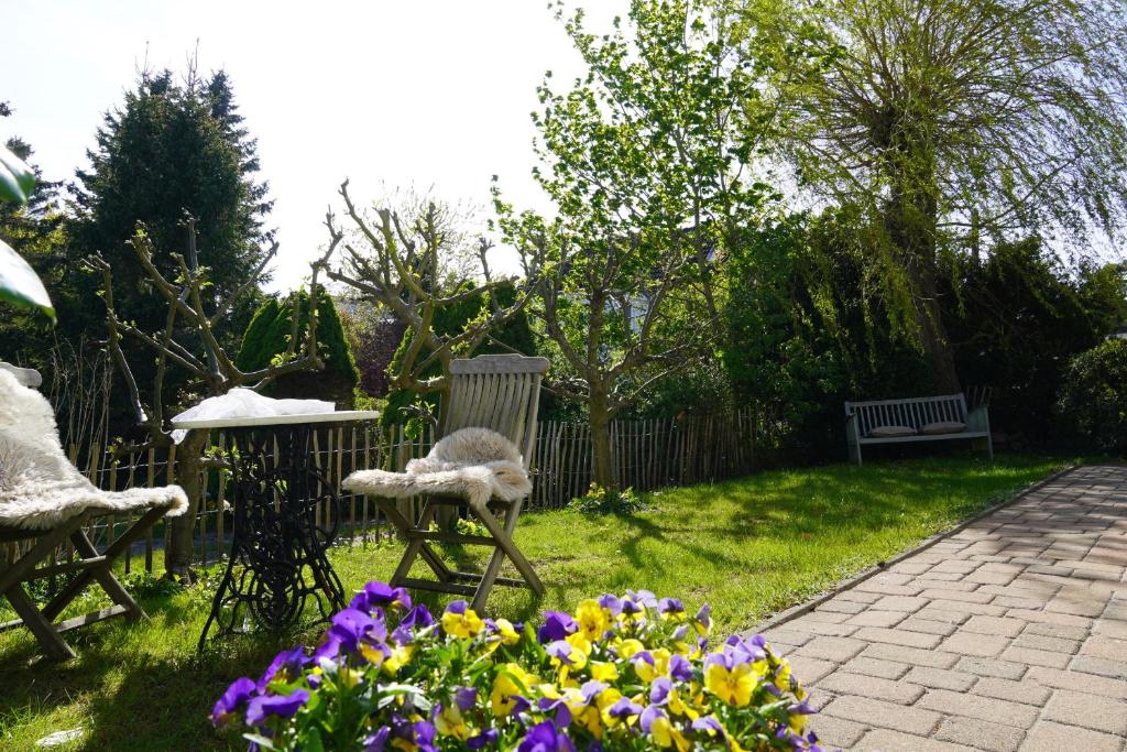 格拉尔-米里茨Ferienwohnung mit Gartenbereich (UT)的花园,花园内摆放着两把椅子,鲜花盛开