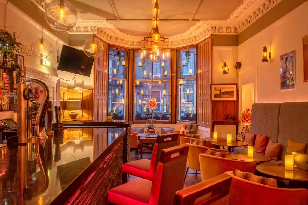 爱丁堡No32 Hotel的餐厅设有桌椅和大窗户。