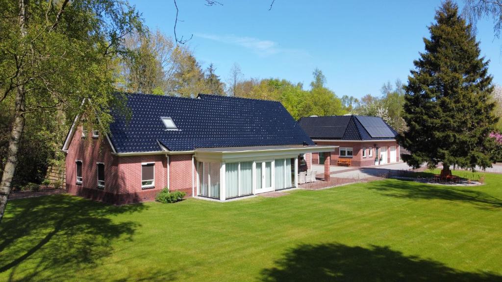 VledderveenB&B Bosstee的一座红砖房子,设有太阳能屋顶
