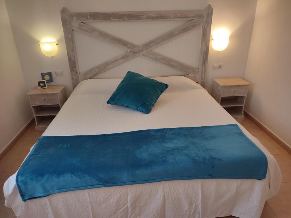 科拉雷侯热带绿洲度假屋的一间卧室配有一张大床,上面有蓝色的枕头