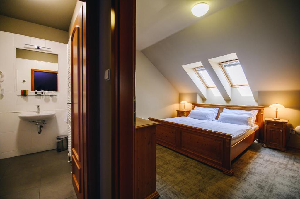 Dolní KouniceKounický dvůr的一间卧室配有一张床,浴室设有天窗。