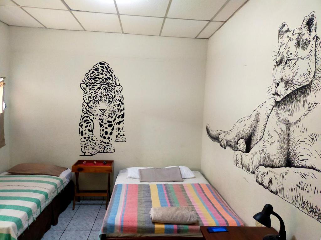 马塔加尔帕Matagalpa Tours Guest House的一间设有两张床的客房,墙上挂着绘画