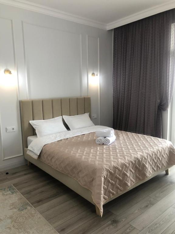 阿斯塔纳Premium Apartments Esil Riverside的一间卧室配有一张床,上面有两条毛巾