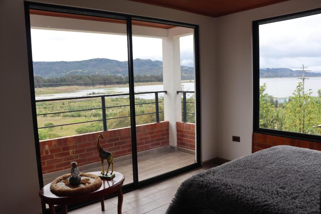 瓜塔维塔Hotel Villa Blanca Guatavita的一间卧室配有一张床,享有水景