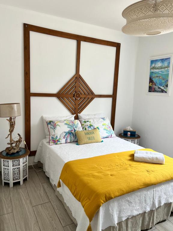 卡佩斯特雷贝勒奥Ti bwa Lodge的一间卧室配有一张带黄色毯子的大床