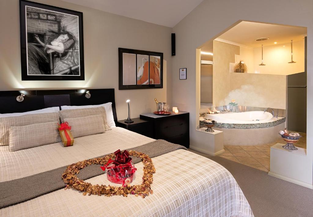 曼纳姆Riverview Rise Retreats的一间卧室设有一张大床和一个浴缸