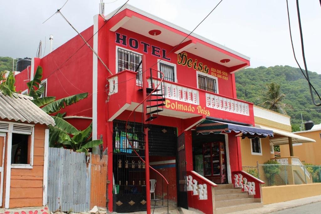 帕托斯Aparta Hotel Los Deisy的红色的建筑,与最靠近街道的酒店