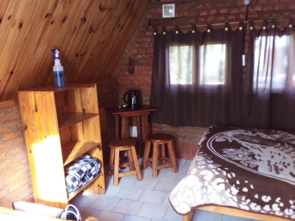 皮拉米德斯港El Cristal的一间卧室配有一张床和两张凳子。