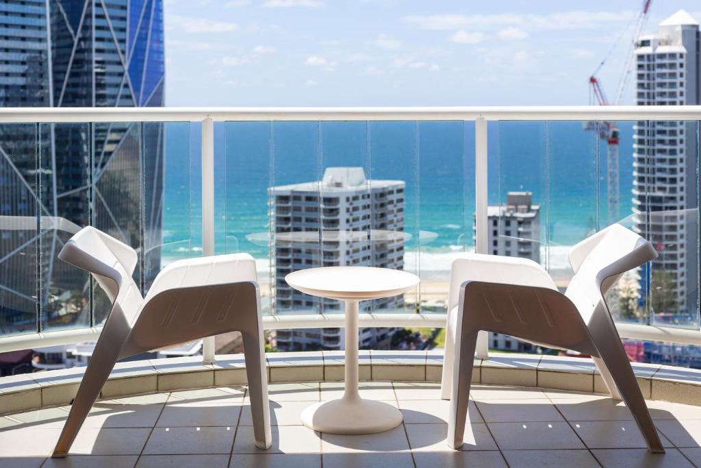 黄金海岸Luxury Ocean View Studio Apartments的海景阳台上的桌椅