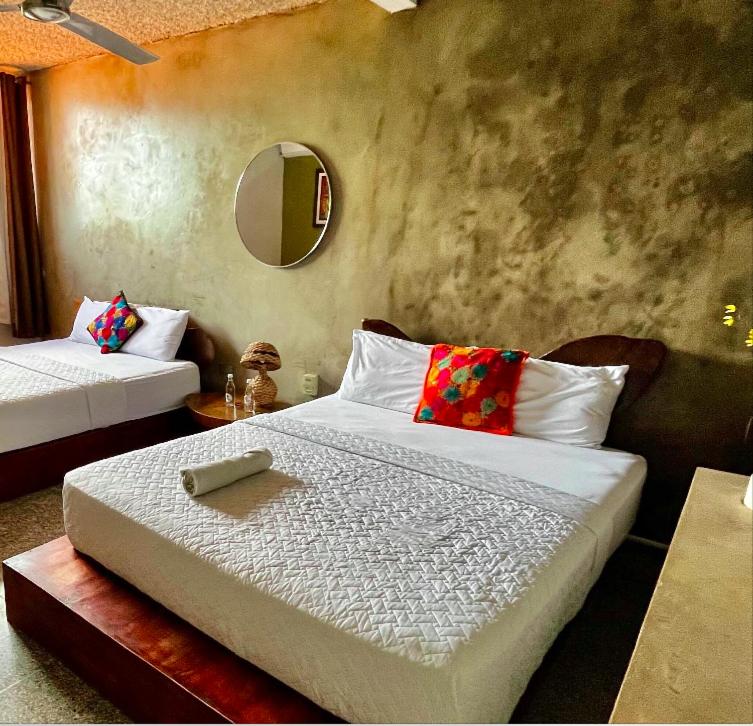 圣萨尔瓦多La Zona Hostel的一间卧室配有两张床和镜子