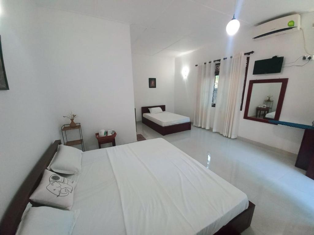 阿努拉德普勒S & D Resort的白色卧室设有一张大床和一张沙发