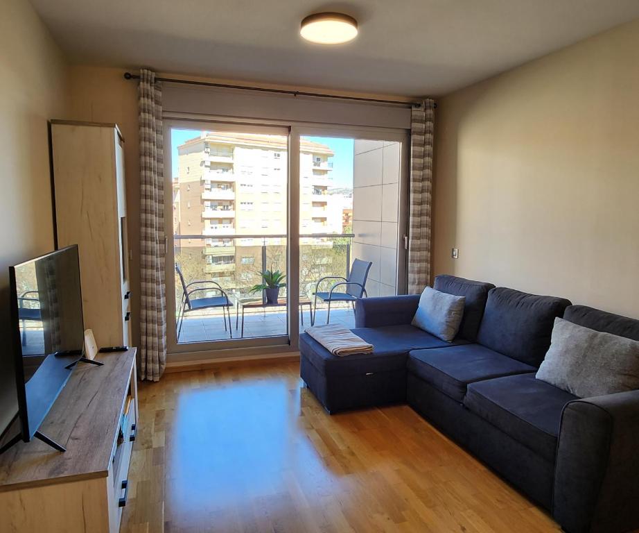 卡斯特利翁-德拉普拉纳Apartamento Bulevar 2的客厅设有蓝色的沙发和大窗户