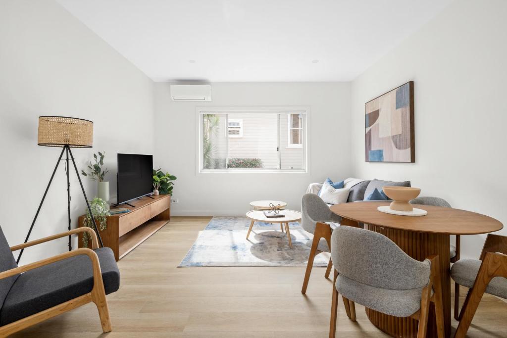 悉尼Urban Rest Neutral Bay Apartments的客厅配有桌子和沙发