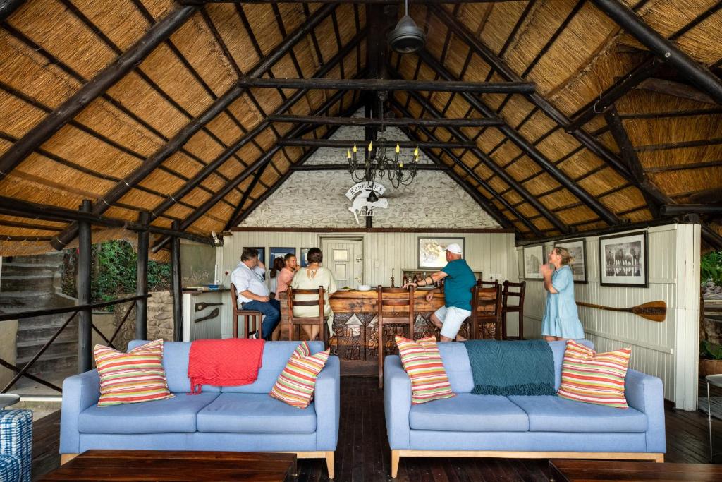 PungaIchingo Chobe River Lodge by Mantis的客厅配有2张蓝色沙发,一群人