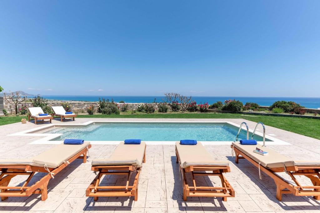 科林比亚Majestic View Villa的一个带躺椅的游泳池和别墅