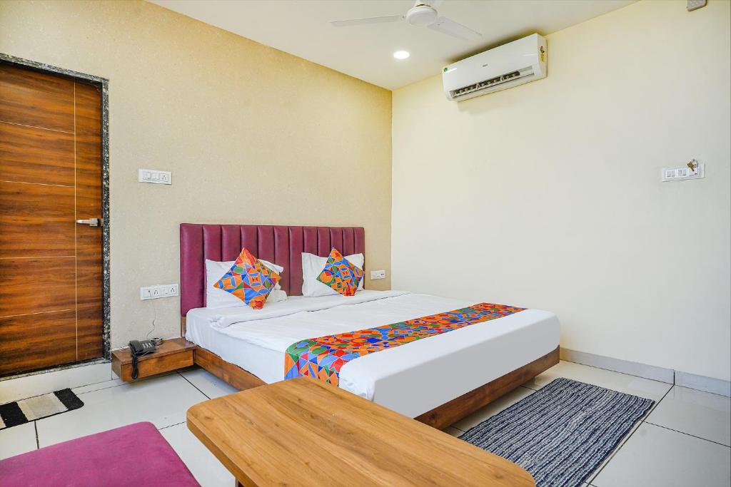 印多尔FabHotel Sukh Vilas的卧室配有一张床和一张桌子
