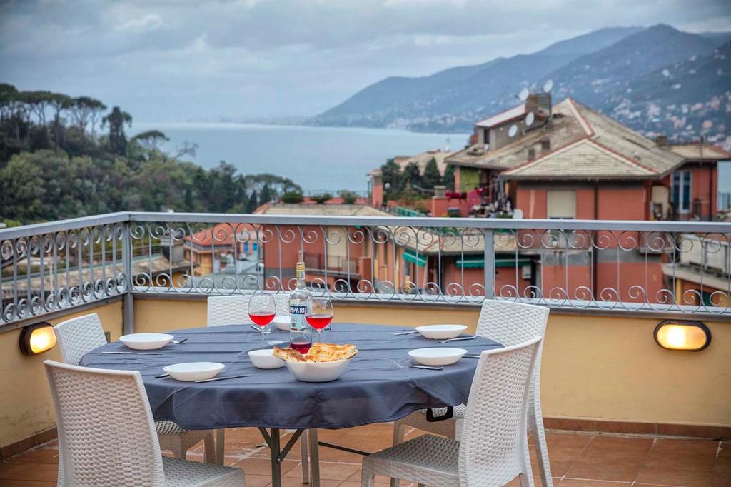 卡莫利Beautiful house with lovely sea view terrace的阳台上的桌子上摆放着酒杯和一碗食物