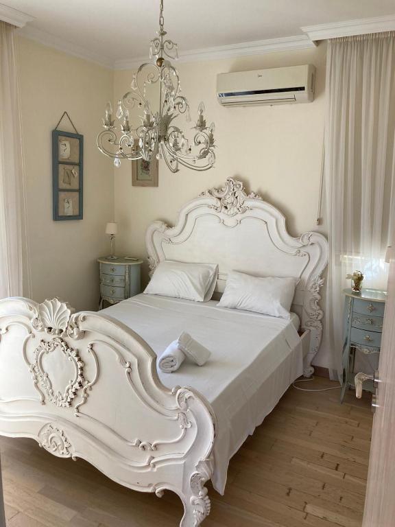 普罗塔拉斯Anna Villa的卧室内的白色床,配有吊灯