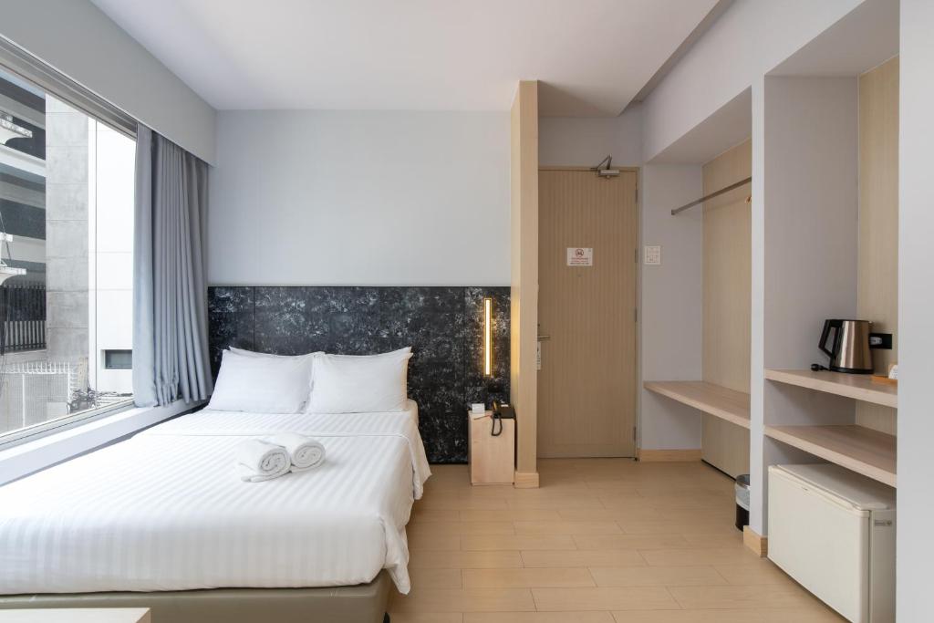 曼谷梅兹巴提南酒店的卧室设有一张白色大床和一扇窗户。