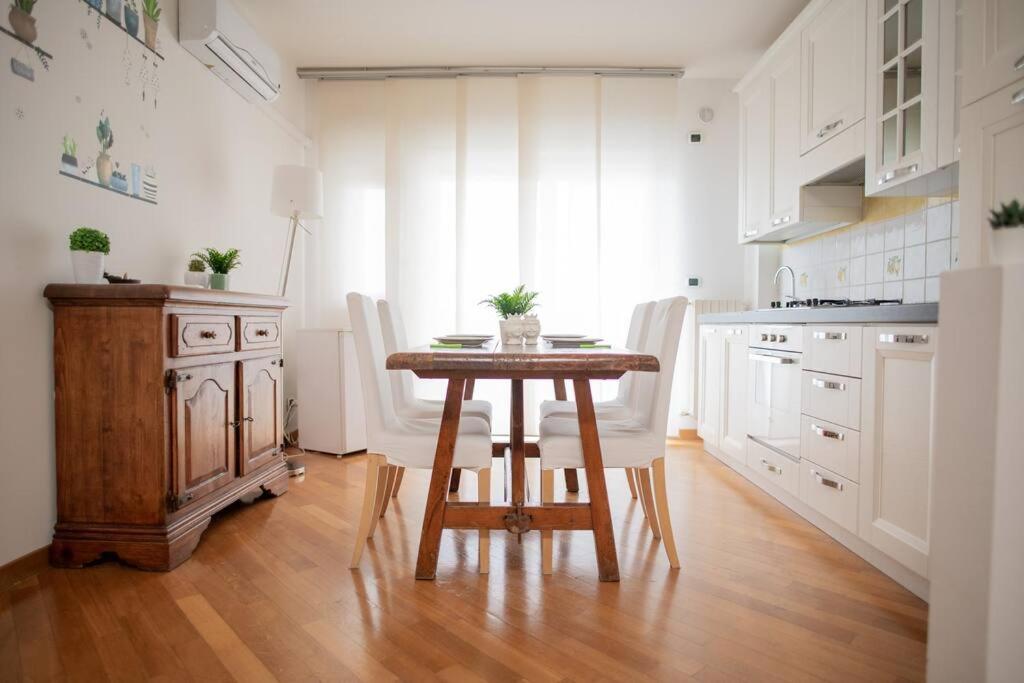 巴里Adriatico Home[Mare-Fiera-Centro]的厨房配有木桌和白色橱柜。