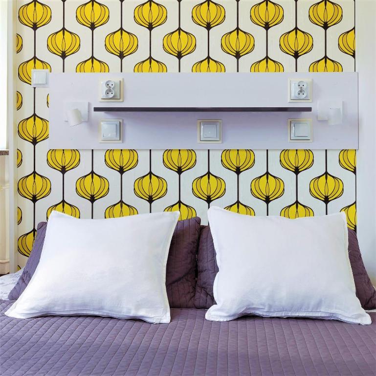华沙塔塔卡旅馆的一间卧室,墙上装饰着黄色花卉壁纸