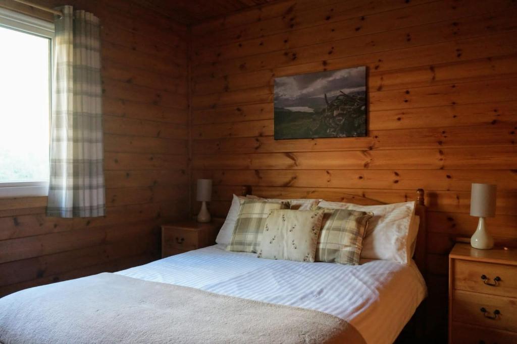 基林Woodland Hazel Lodge的一间卧室配有一张木墙床