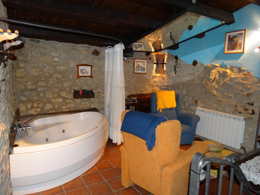 La CubaCasa La Cantonera con zona relax jacuzzi的一间带大浴缸和椅子的浴室