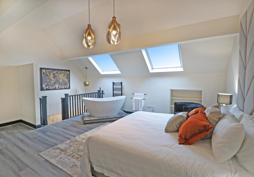 滨海索尔特本Black Pearl Stays - Saltburn Apartments的卧室配有一张白色大床和浴缸