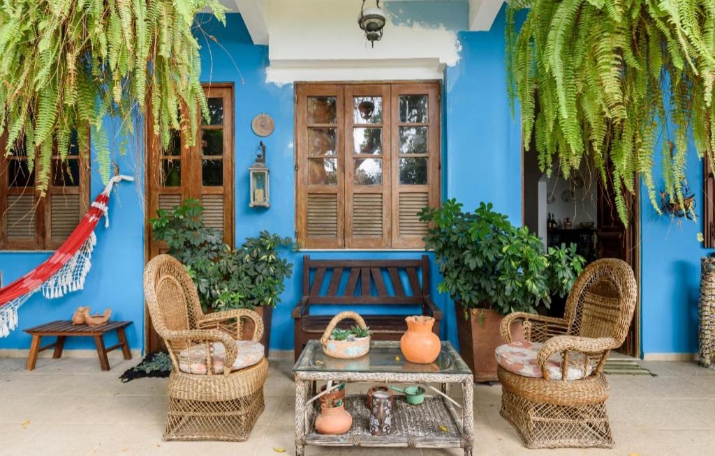 里约热内卢Santa Teresa Junto à Natureza的蓝色的建筑,配有长凳、椅子和桌子