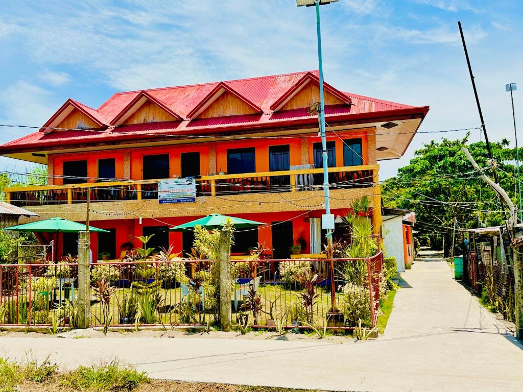 马拉帕斯加Edem Tourist Inn Malapascua的红色的建筑,有红色的屋顶