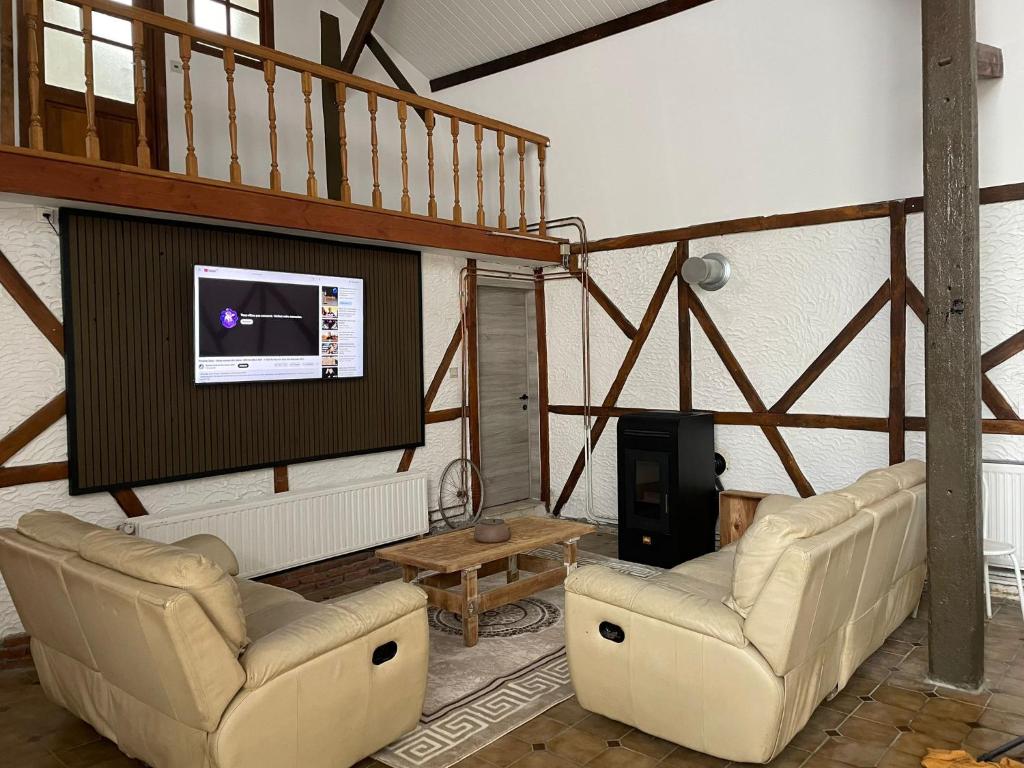 La BruyèreLa bergerie的客厅配有2把椅子和平面电视