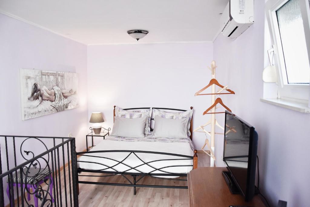 斯普利特Lavender cozy & lovely 17的一间小卧室,配有一张床和电视