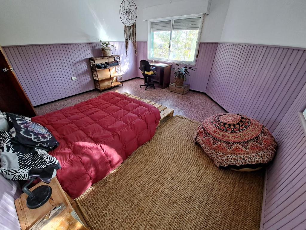 Treinta y TresCasa Agni的一间卧室配有一张红色的大床和一张桌子