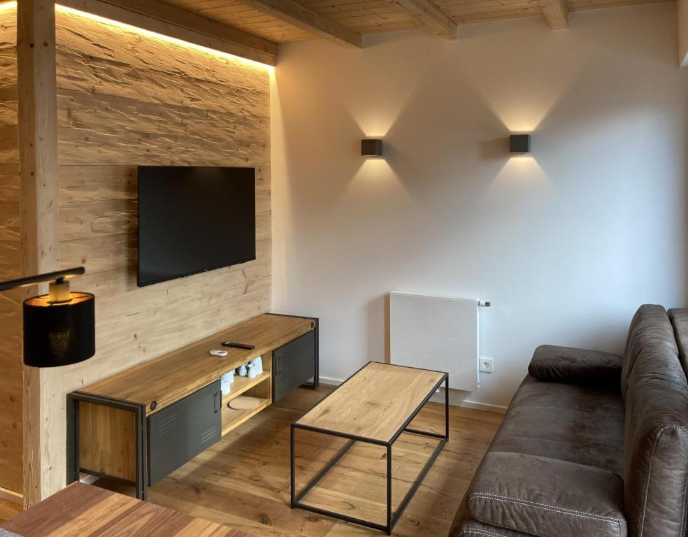 菲尔德施塔特Filder-Appartements的客厅配有沙发和墙上的电视