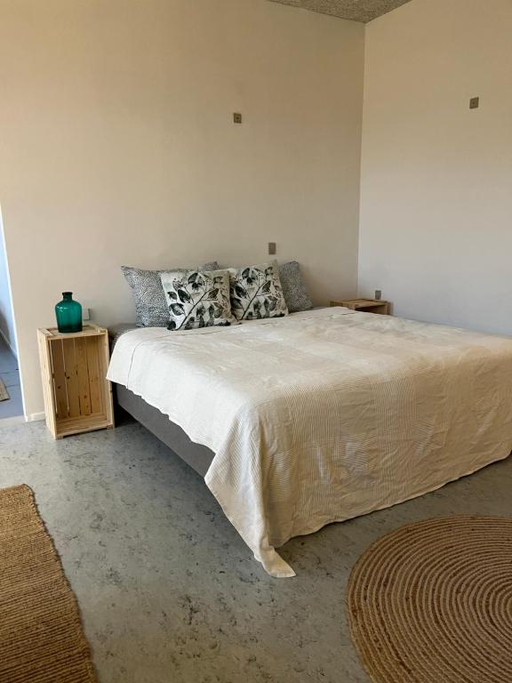 韦斯特维Room 6 - Hawkraft Kulturhotel的卧室配有一张带白色床单和枕头的大床。