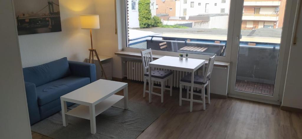门兴格拉德巴赫Frisch renoviertes Appartement的客厅配有桌子和蓝色沙发