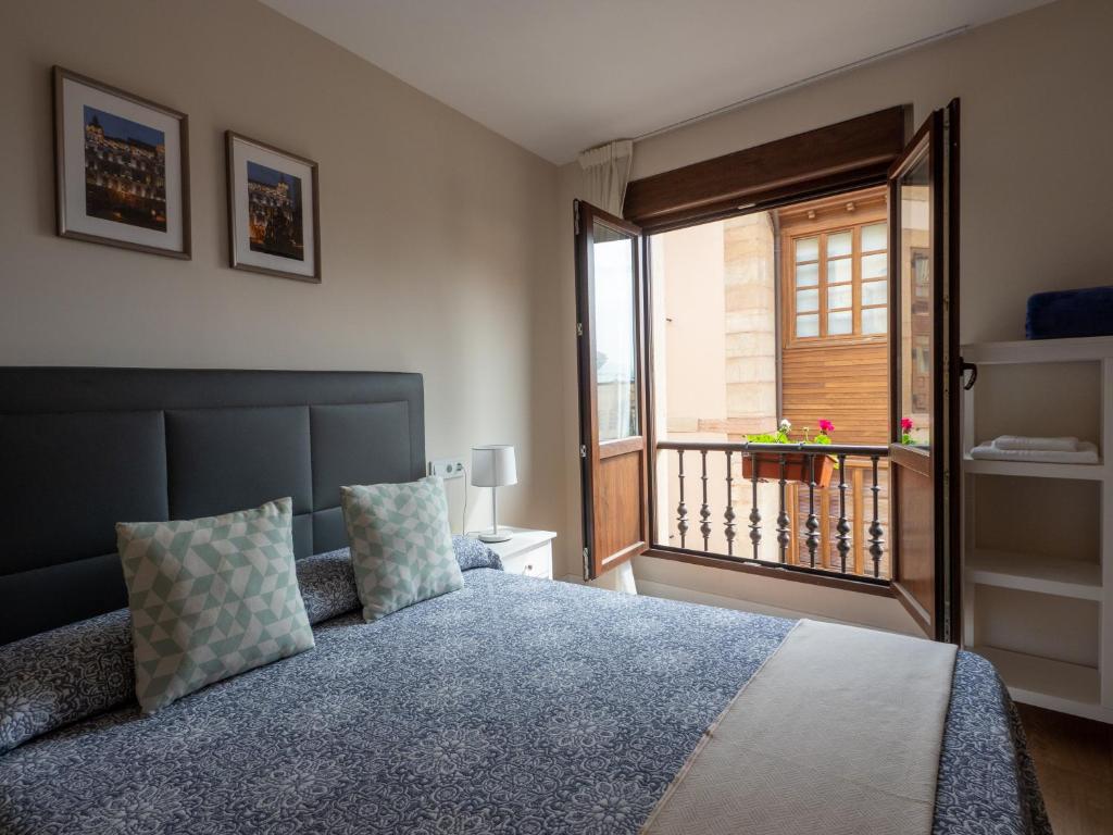 奥维多Apartantiguo San Isidoro10的一间卧室设有一张床和一个阳台的窗户。