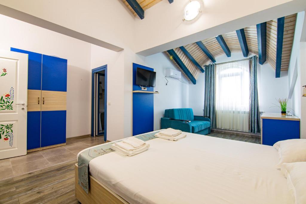 杜纳厄图德乔斯Pensiunea Pelicanul的一间卧室配有蓝色橱柜和白色的床