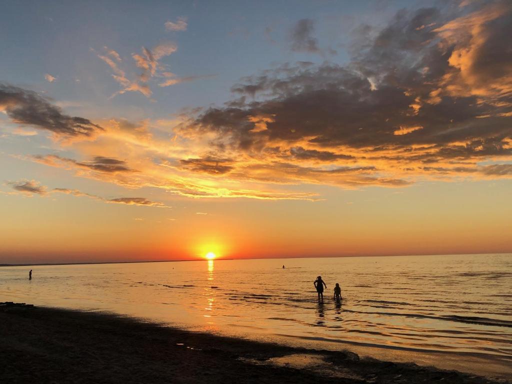BabīteVilla Magnolia的日落时分,两个人站在海滩上