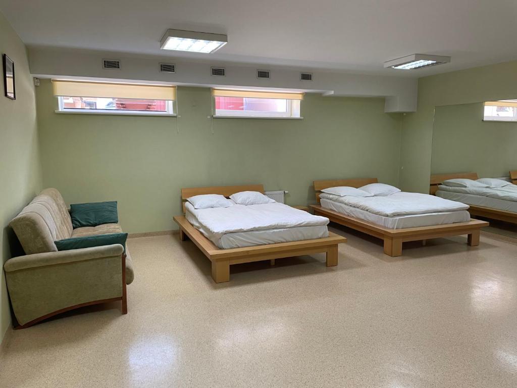 克莱佩达Aismares Hostel的一间医院间,配有两张床和椅子