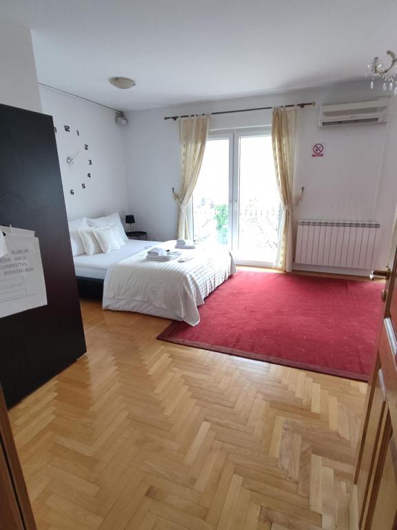萨拉热窝Villa Kuna的卧室配有白色的床和红色地毯。