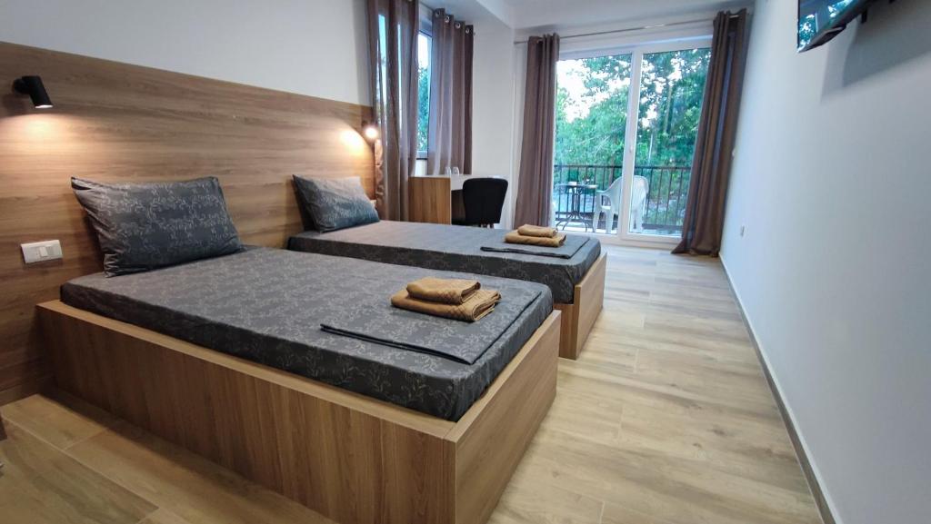 奥赫里德Villa Natali的一间卧室设有两张床和大窗户