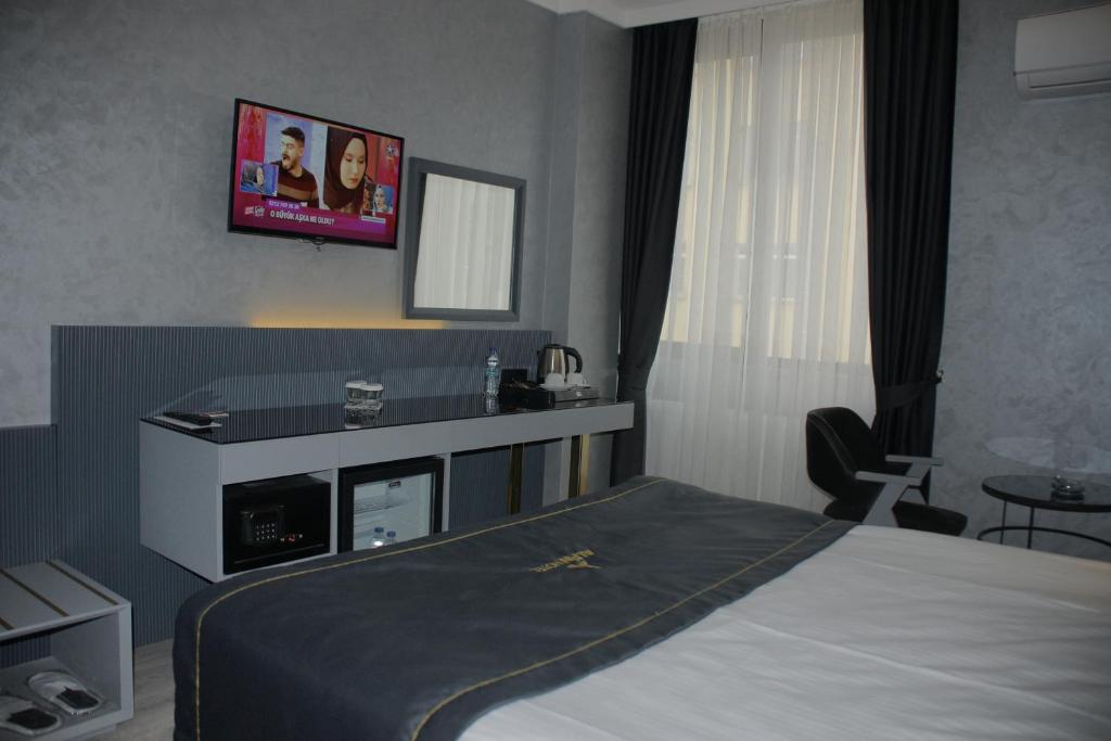 安卡拉阿尔芬酒店的卧室配有一张床,墙上配有电视。