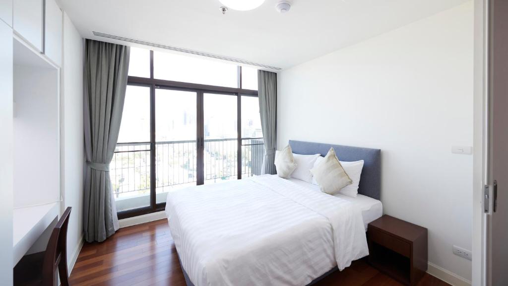 MakkasanCitiresort Living sukhumvit 39的卧室设有白色的床和大窗户